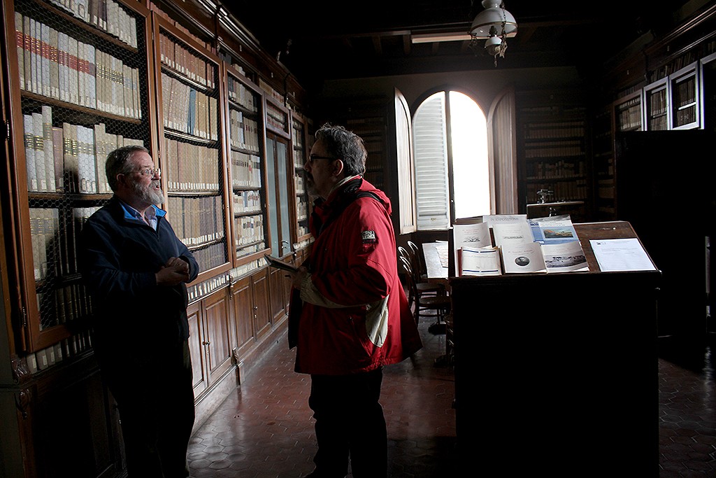 Aubrey Westinghouse, responsable del Observatorio Ximeniano, explica al autor las particularidades de la biblioteca astronómica. Foto: © Lola Vázquez